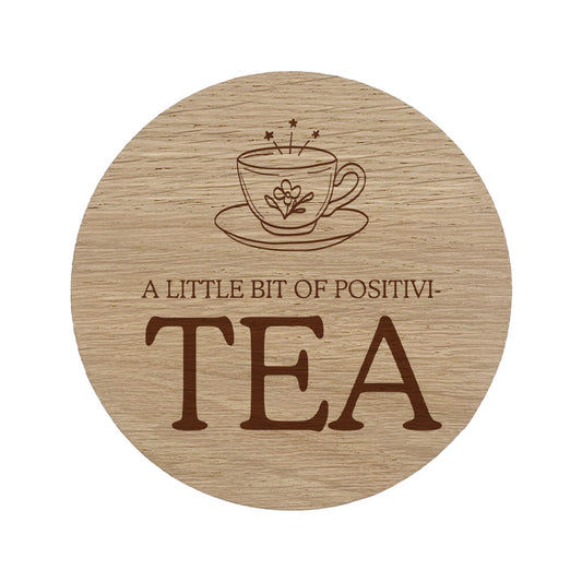 Wooden coaster with tea cup design and quote 'A Little Bit of Positivi-TEA' on a white background
