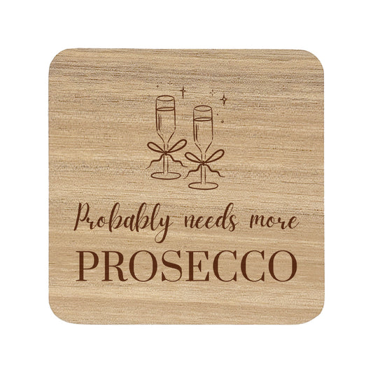 Wooden coaster with champagne glasses and text 'Probably needs more Prosecco' on a white background