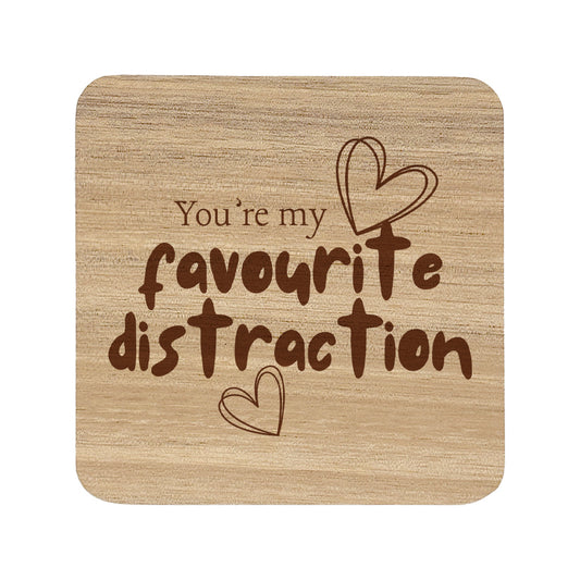 Square wooden coaster with the quote 'You're my favourite distraction' and heart illustrations.