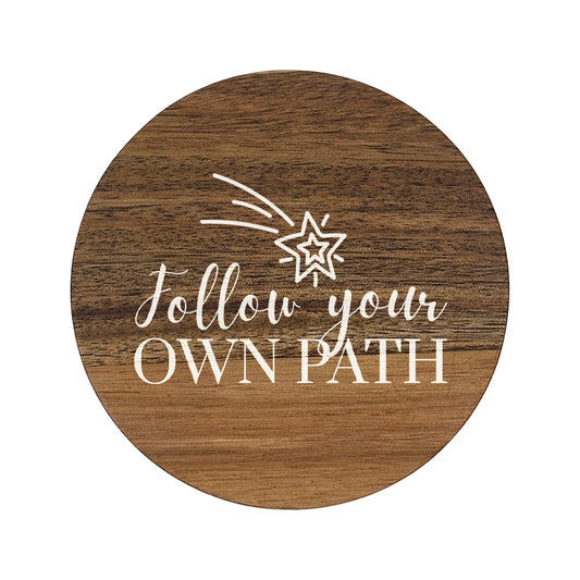 Round wooden coaster with 'follow your own path' white text and shooting star illustration.