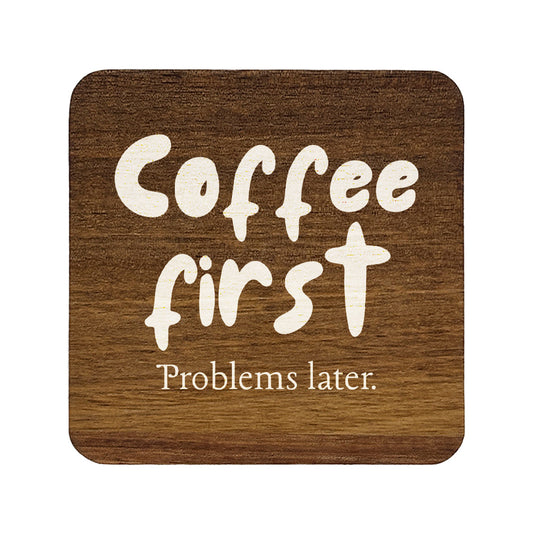 Square wooden coaster with 'Coffee first Problems later.' text on a white background