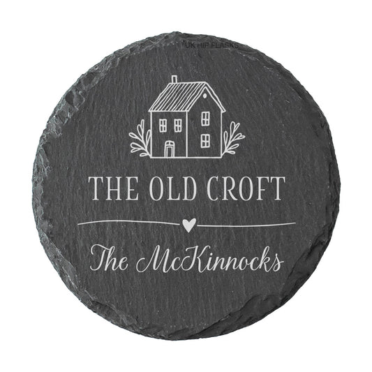 Round personalised house name or number slate coaster, personalised with a house name and family name, with a cute house illustration.