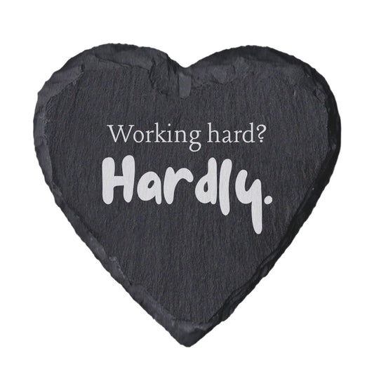Heart-shaped slate coaster with 'Working hard? Hardly.' text on a white background