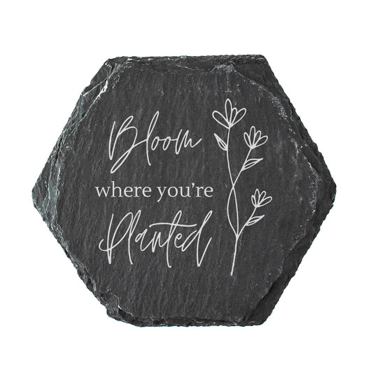 Hexagonal slate coaster with 'Bloom where you're planted' text and floral design on a white background