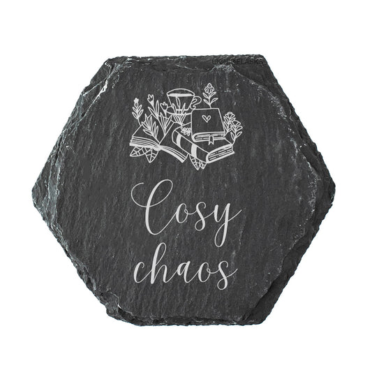 Hexagonal black slate coaster with white text design and text 'Cosy chaos' on a white background