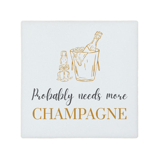 Square ceramic coaster featuring the funny quote "Probably needs more champagne" in crisp grey and gold lettering with a champagne bottle illustration.