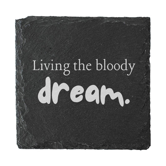 Slate coaster with 'Living the bloody dream.' text on a white background