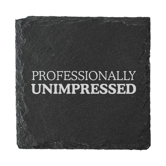 Black slate coaster with 'PROFESSIONALLY UNIMPRESSED' text on a white background
