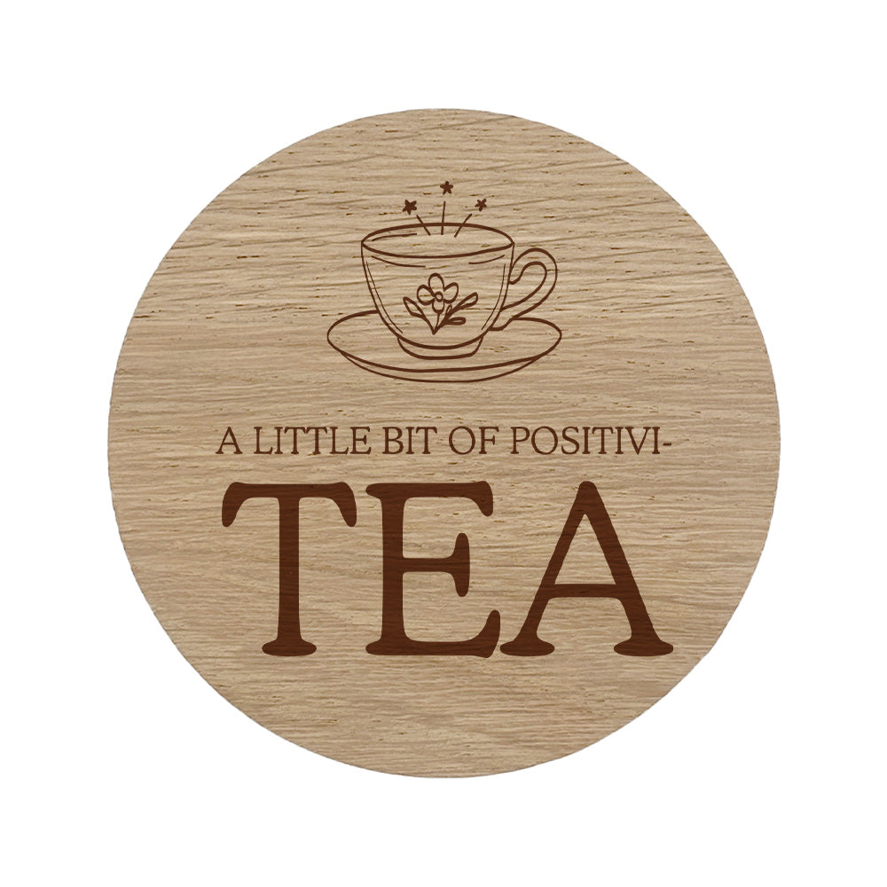 Wooden coaster with tea cup design and quote 'A Little Bit of Positivi-TEA' on a white background