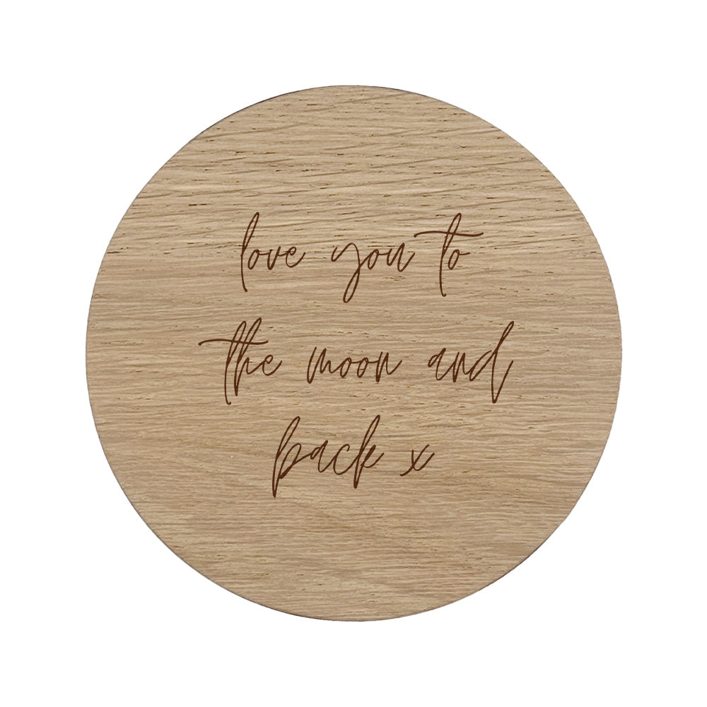 Round wooded coaster with quote "love you to the moon and back x" in handwriting style lettering.