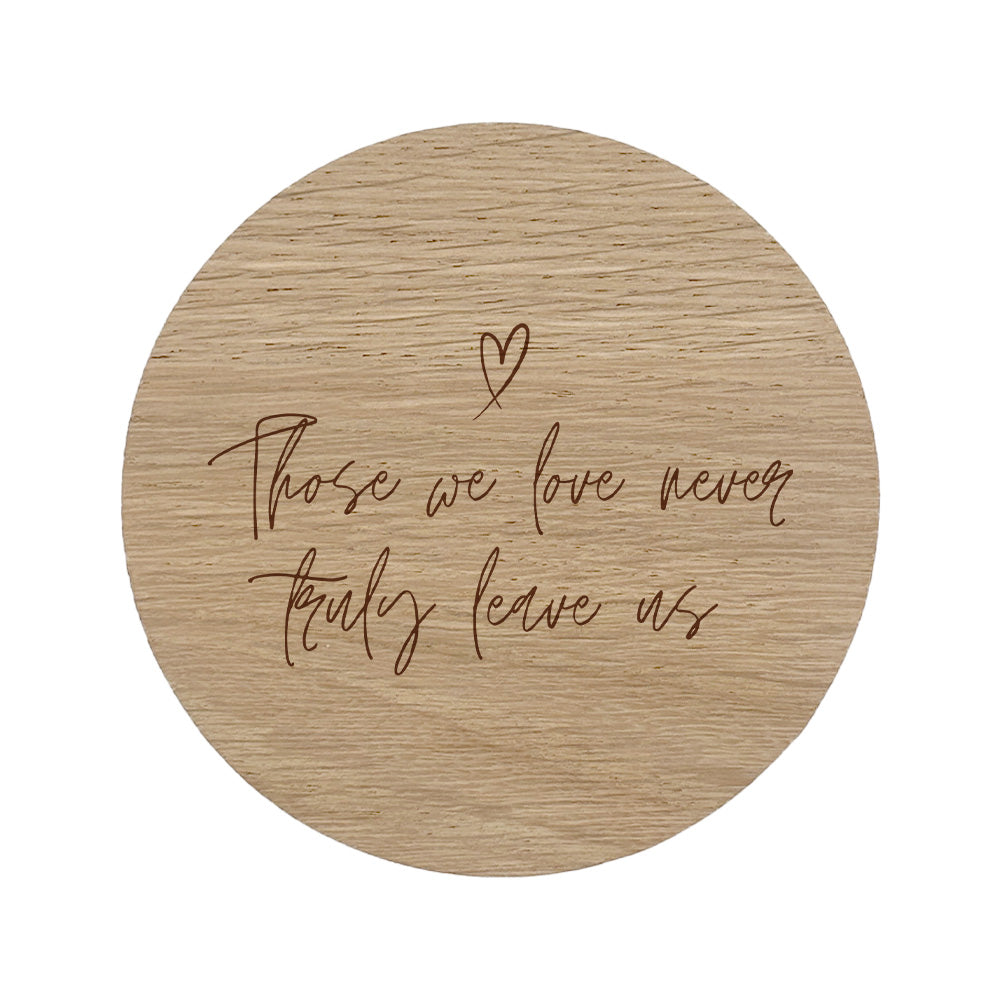 Wooden coaster with "those we love never truly leave us" text and heart symbol on a white background