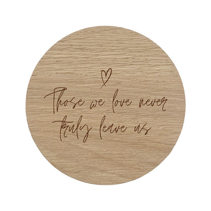 Wooden coaster with "those we love never truly leave us" text and heart symbol on a white background