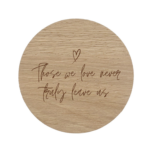 Wooden coaster with "those we love never truly leave us" text and heart symbol on a white background