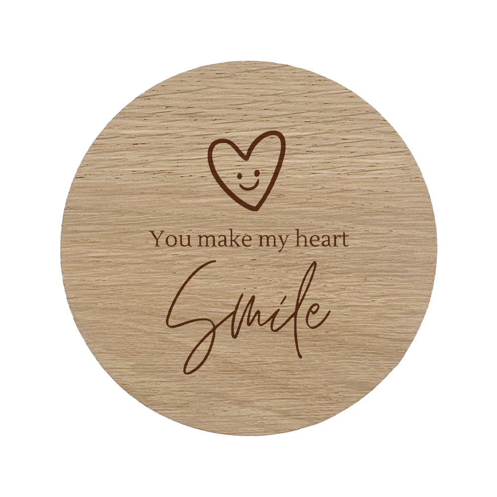 Round wooden coaster with a heart and "You make my heart smile" text design on a white background