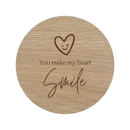 Round wooden coaster with a heart and "You make my heart smile" text design on a white background