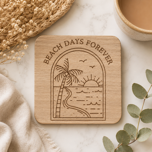 A square wooden coaster with the quote "beach days forever" and a beach scene illustration on a marble surface with coastal decorations around it.