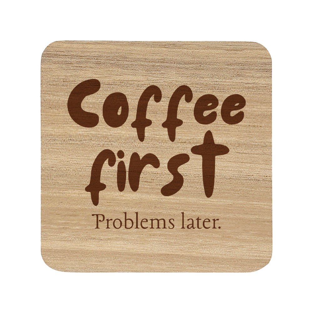 Wooden coaster with 'Coffee first Problems later.' text on a white background
