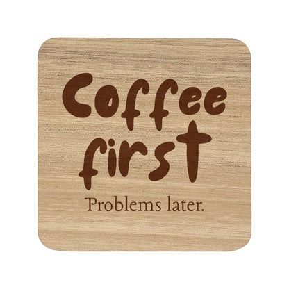 Wooden coaster with 'Coffee first Problems later.' text on a white background