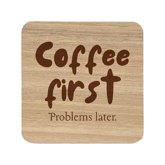 Wooden coaster with 'Coffee first Problems later.' text on a white background