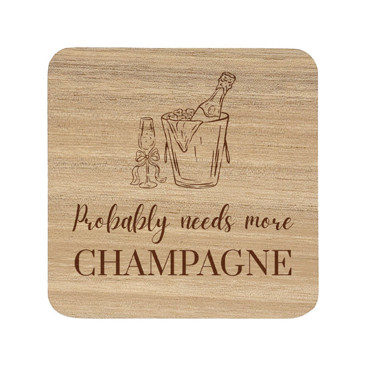Square wooden coaster featuring the funny quote "Probably needs more champagne" in crisp lettering with a champagne bottle and glass illustration