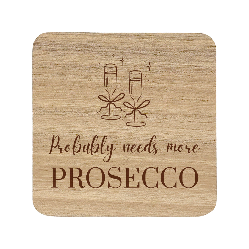 Wooden coaster with champagne glasses and text 'Probably needs more Prosecco' on a white background