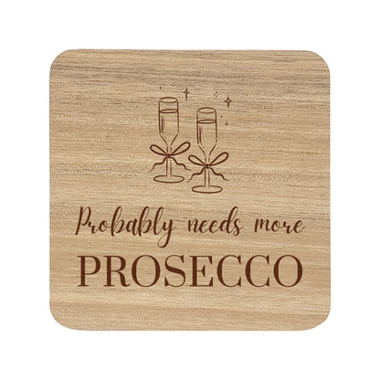 Wooden coaster with champagne glasses and text 'Probably needs more Prosecco' on a white background
