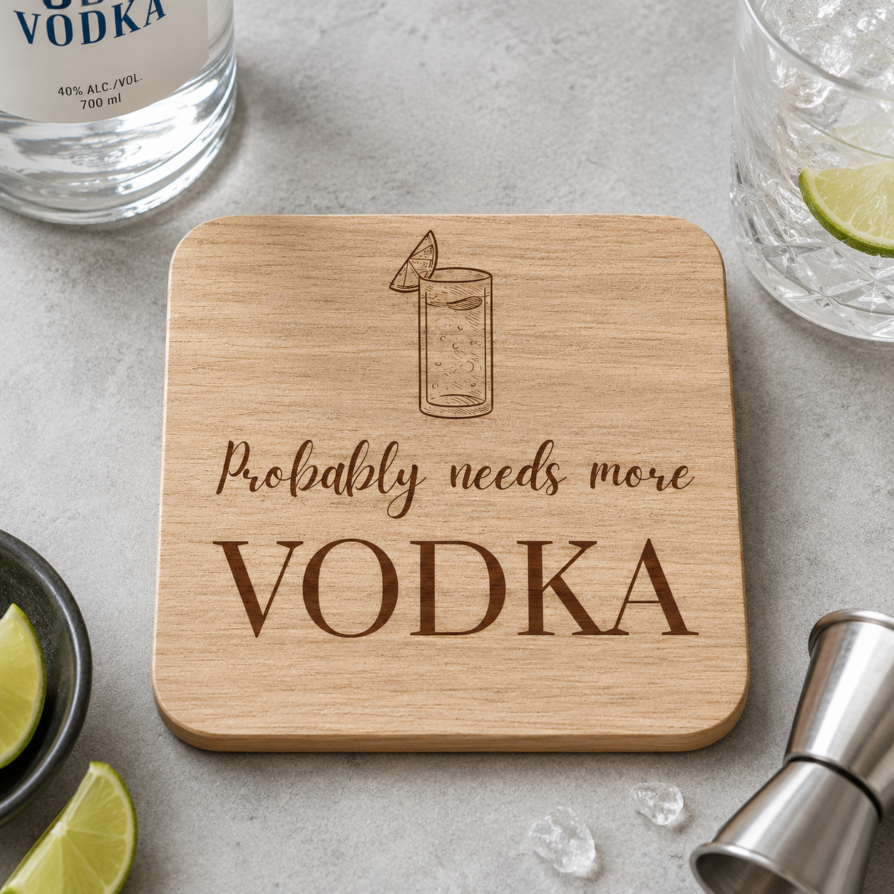 Wooden coaster with 'Probably needs more VODKA' text on a table with a bottle of vodka and glass.