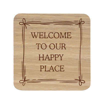Square wooden coaster featuring the quote "Welcome to our happy place" in crisp lettering with a cute bow border.