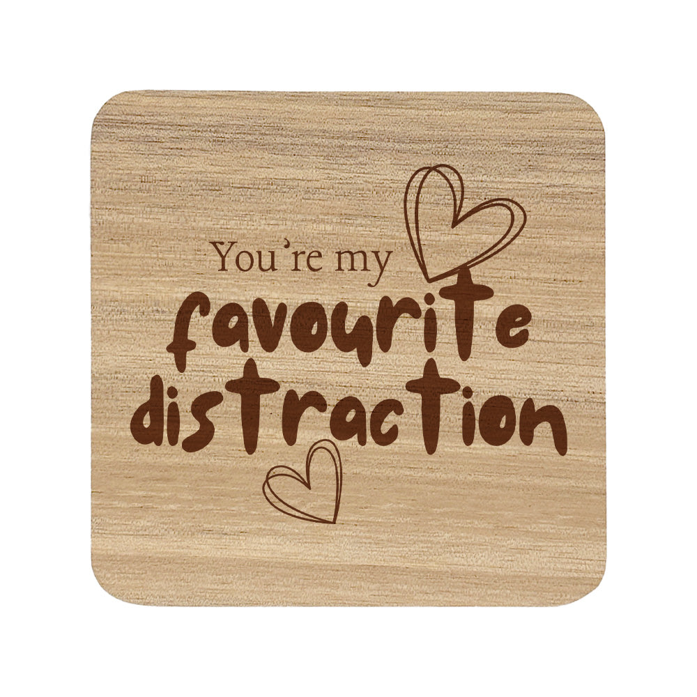 Square wooden coaster with the quote 'You're my favourite distraction' and heart illustrations.