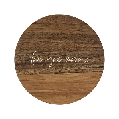 Round wooden coaster with 'Love you more x' text on a white background