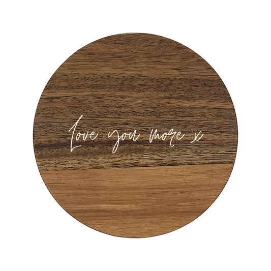 Round wooden coaster with 'Love you more x' text on a white background