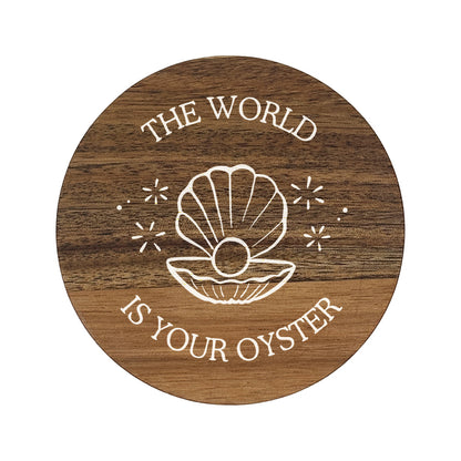 Round wooden coaster with 'The World Is Your Oyster' text and shell illustration on a white background