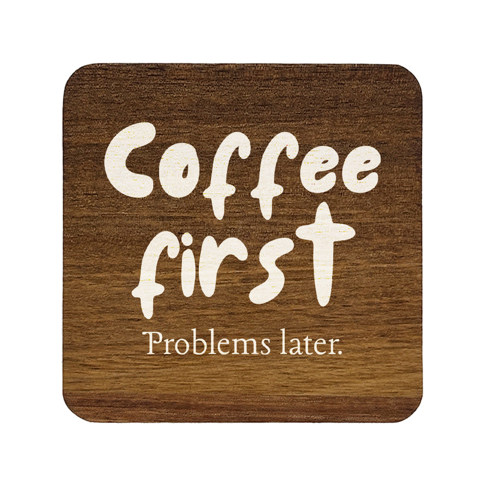 Square wooden coaster with 'Coffee first Problems later.' text on a white background
