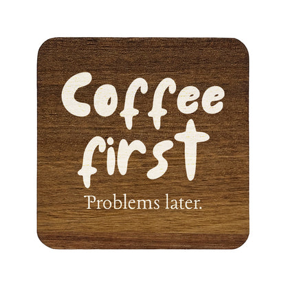 Square wooden coaster with 'Coffee first Problems later.' text on a white background
