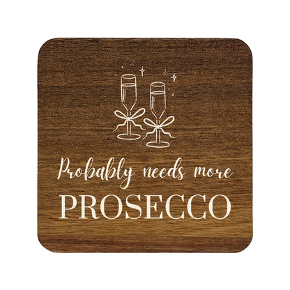 Square wooden coaster with champagne glasses and text 'Probably needs more Prosecco' on a white background