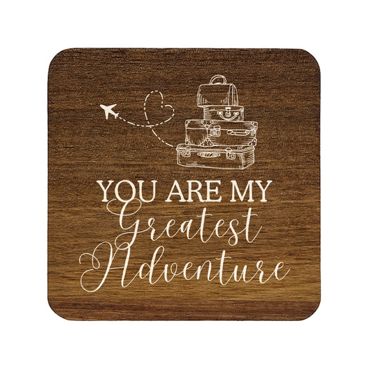 Square wooden coaster with 'you are my greatest adventure' quote in white text with suitcase and aeroplane illustration.