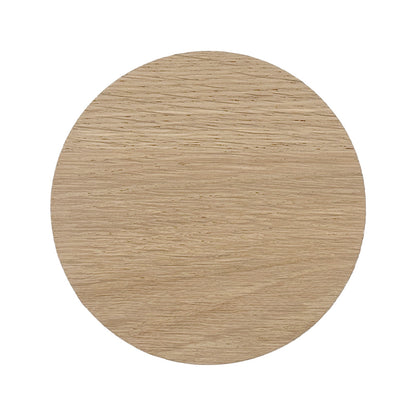 The back of a round wooden coaster with a natural finish on a white background