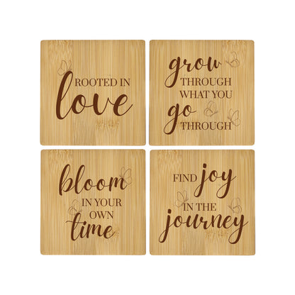 A set of 4 bamboo wood coasters decorated with inspirational quotes about growth and transformation, and decorated with a butterfly motif.