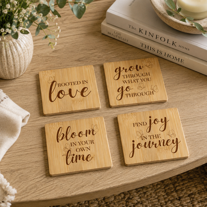A set of 4 bamboo wood coasters on a wooden coffee table, decorated with inspirational quotes about growth and transformation.