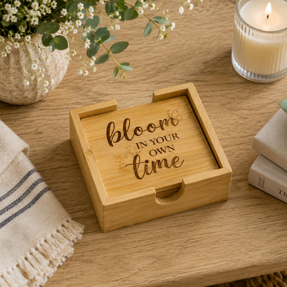 A set of 4 bamboo wood coasters decorated with inspirational quotes and stored in a matching bamboo box. The set is on a wooden coffee table.
