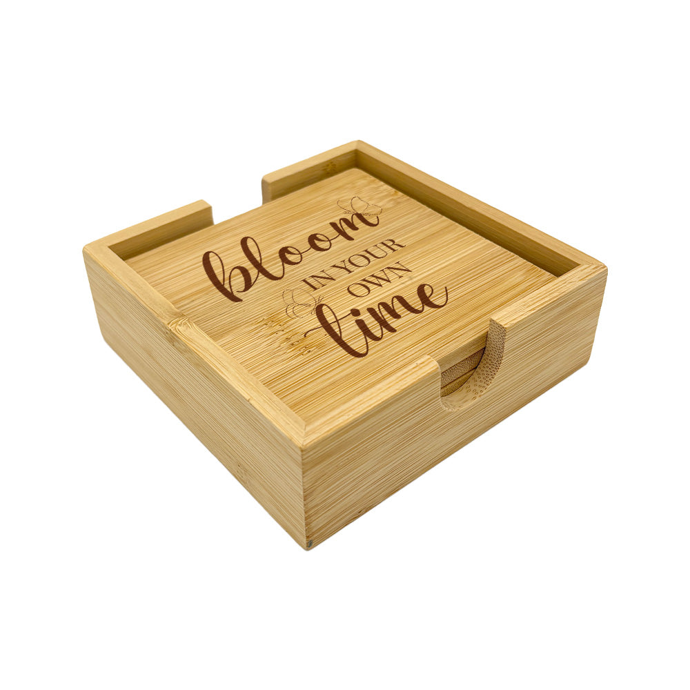 A set of 4 bamboo wood coasters decorated with inspirational quotes and stored in a matching bamboo box.