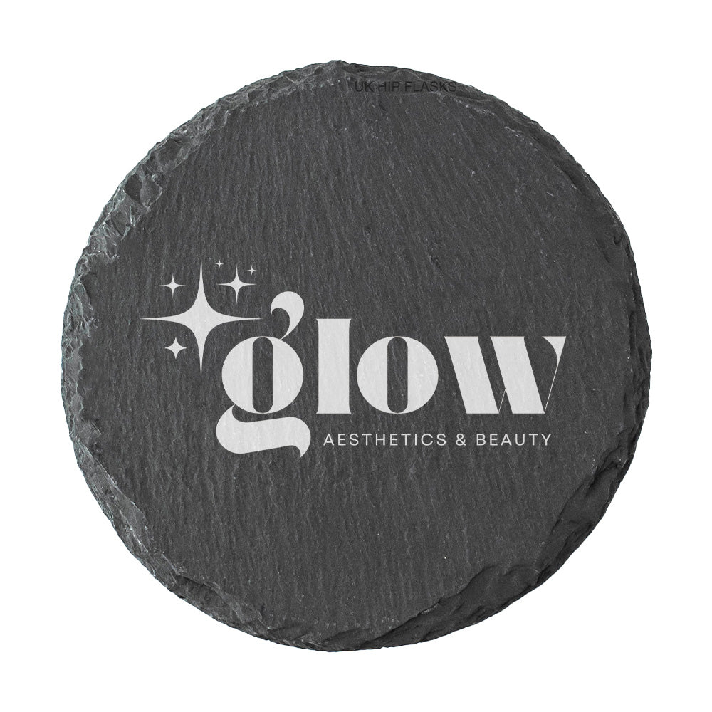 A round dark grey slate coaster personalised with a white printed logo for a beauty salon and aesthetics clinic. Your logo here.