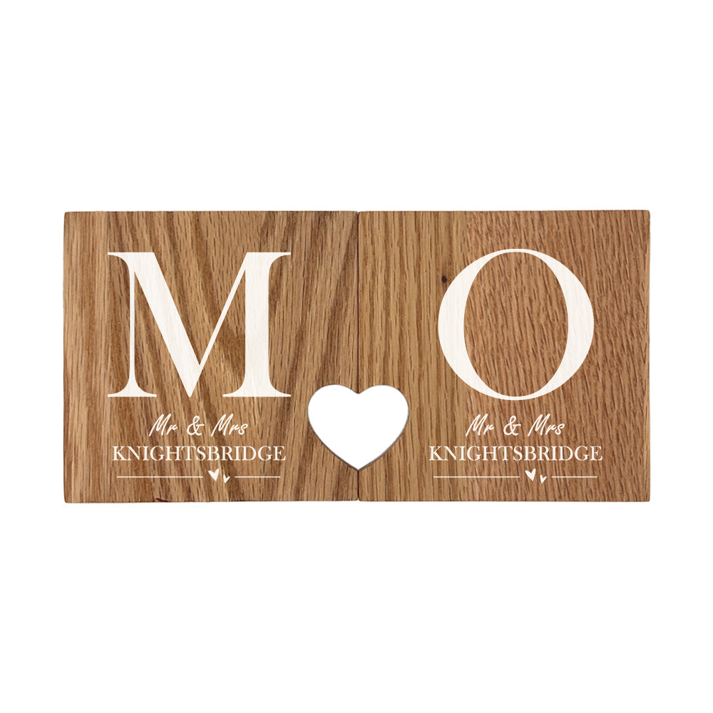 A set of 2 oak wooden coasters personalised with couple's initials and married name. When placed together the cut-out on each coaster forms a heart shape. 