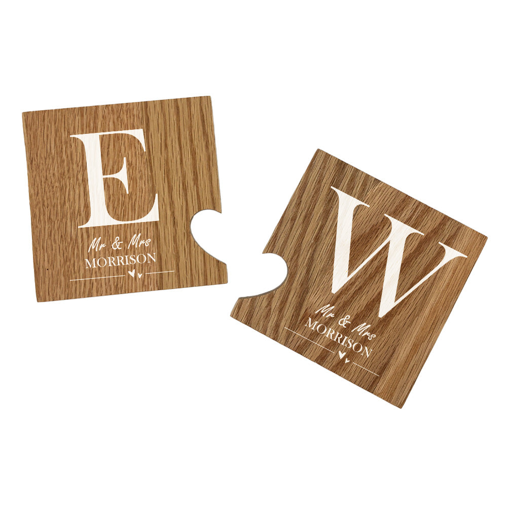 A set of 2 oak wooden coasters personalised with couple's initials and married name. When placed together the cut-out on each coaster forms a heart shape. 