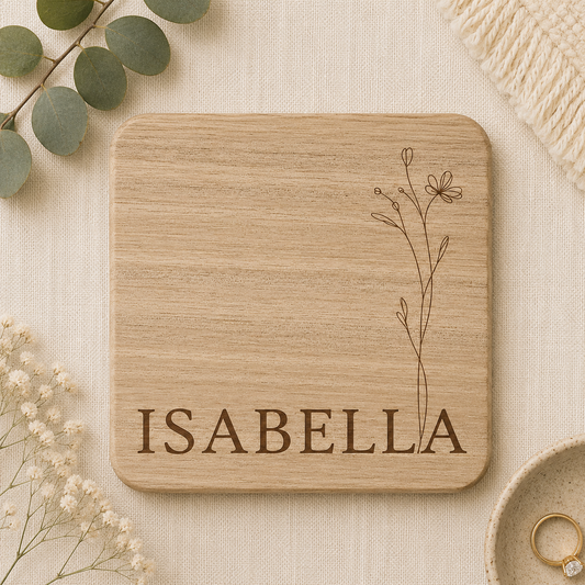 Wooden coaster with personalised name on a beige background with decorative elements.