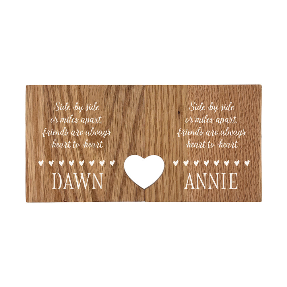 A set of 2 oak wooden coasters with a friendship quote and personalised with best friend's names. When placed together the cut-out on each coaster forms a heart shape.
