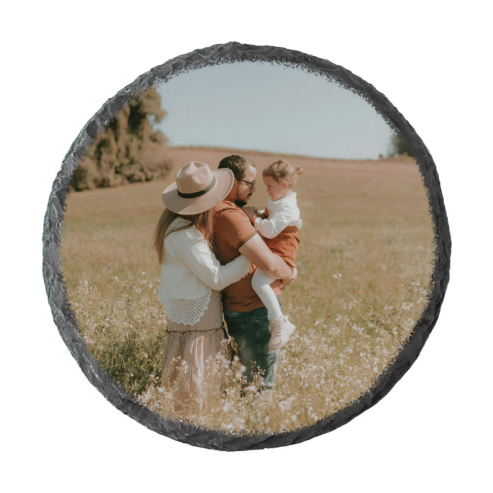Round slate coaster with a family photo of a man, woman, and child in a field.