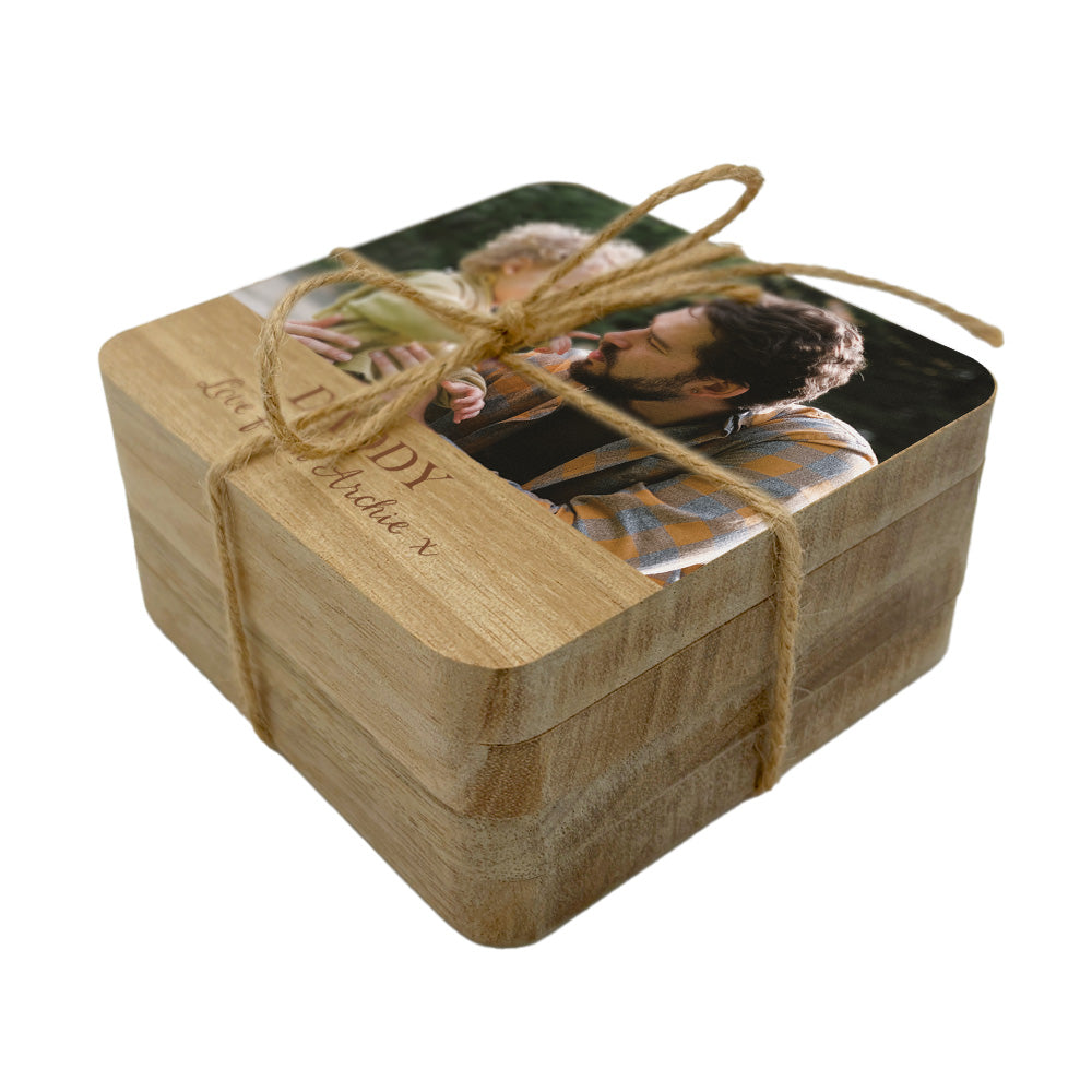 A set of square personalised wooden coasters tied with twine, with a family photo and personalised text.