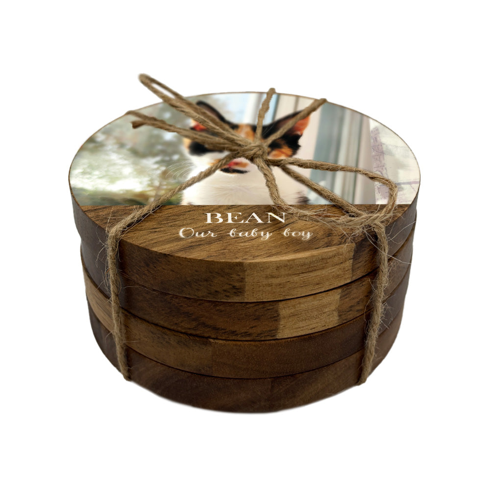 Stack of wooden coasters personalised with a photo and custom text, tied with twine on a white background.