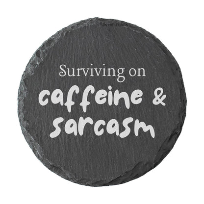 Round coaster with the quote "surviving on caffeine and sarcasm" in white text.